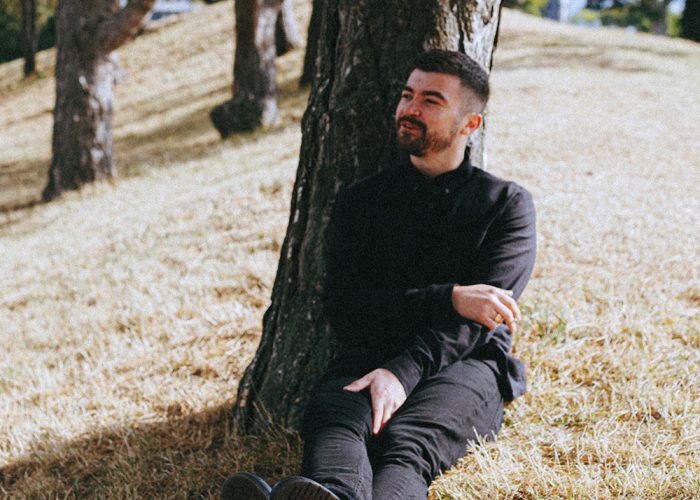 Sean McGowan Sat on the grass in front of a Tree.